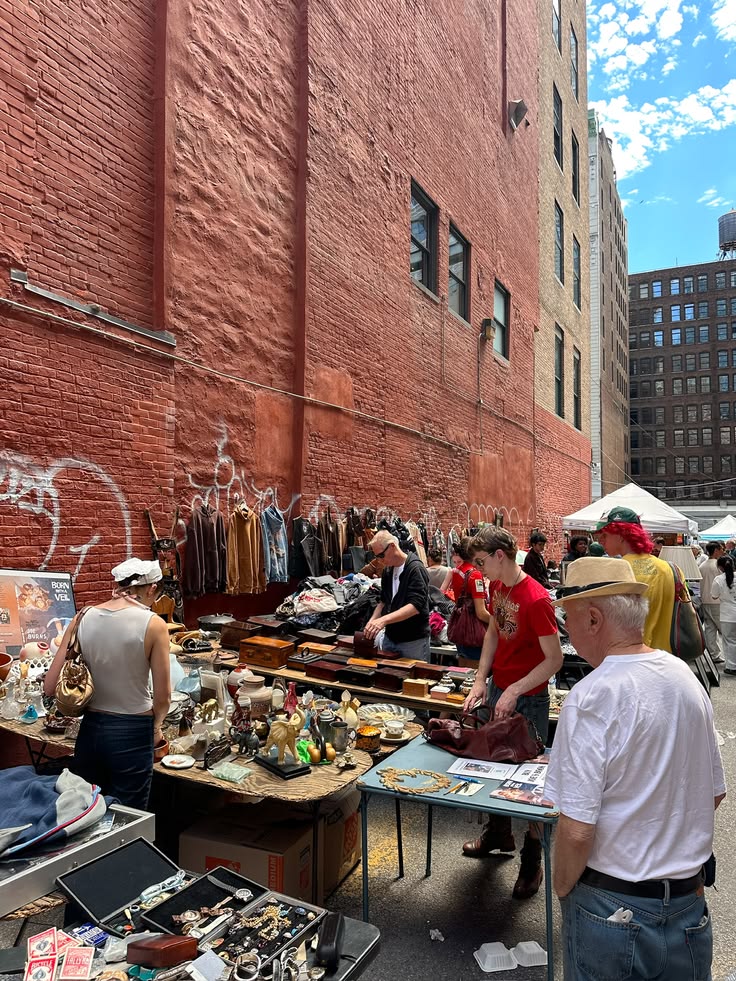 Shoppers browsing tables of vintage finds at an outdoor NYC flea market